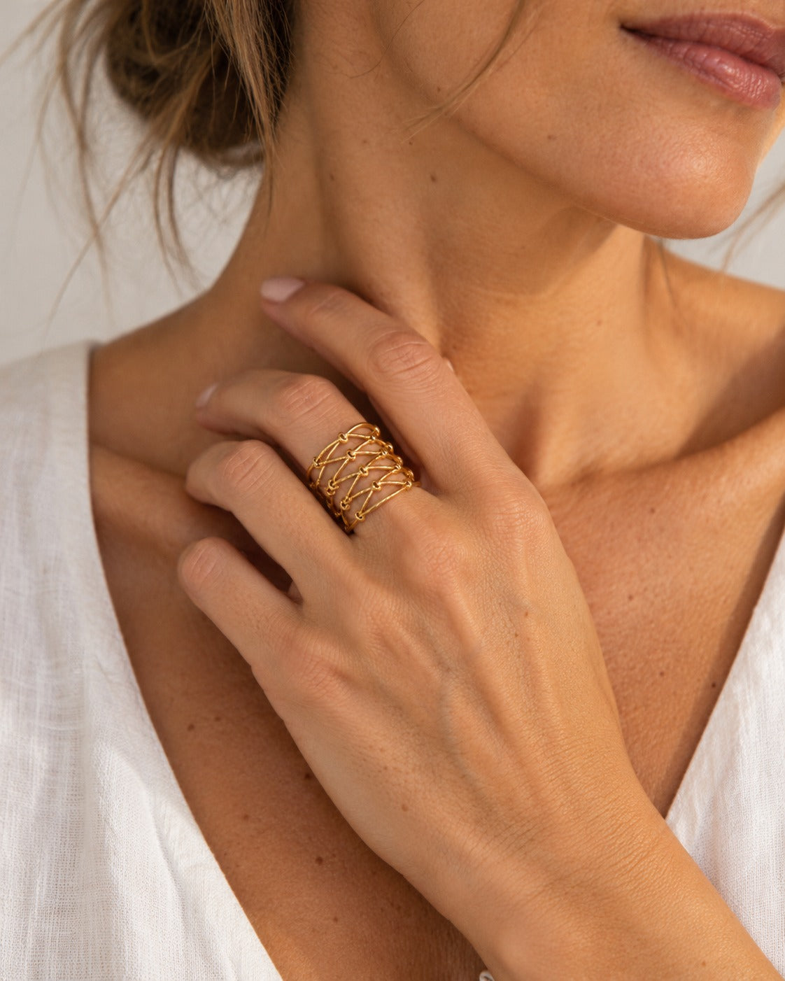 Anillo Sidonie dorado puesto en mano de modelo